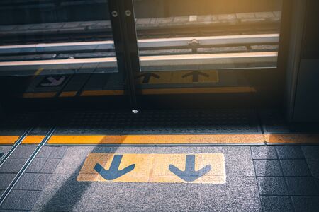 The arrow symbol for the entrance and exit of the passengers in the sky train BTS station.の写真素材