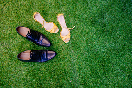 Shoes of the bride and groom on grass floorの写真素材
