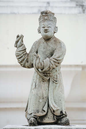 Chinese Stone Statues in dancing manners  stand near the door in Thai templeの写真素材