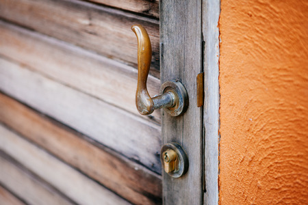 Close-up vintage style door handle of brass on old wooden door. Selective focus.の写真素材
