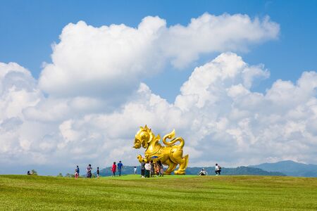 CHIANG RAI, THAILAND - October 26, 2019 : Tourists are taking photos with a large golden Singha (Lion) statue at Singha Park (Boon Rawd Farm), Chiang Rai province, Thailandのeditorial素材