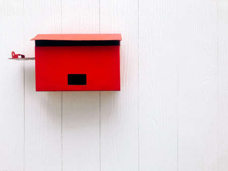 Red mailbox on white wooden wall with space for wordingの写真素材