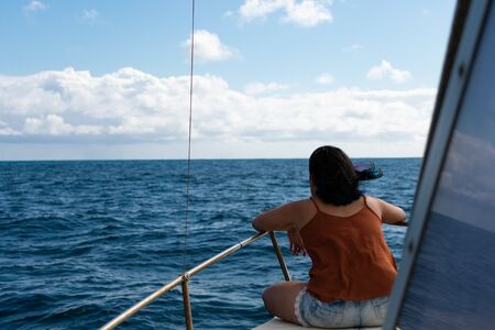 Women overlooking the sea horizon on small boatの写真素材
