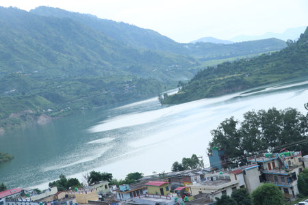 The landscape view of the river and the village in the mountains.