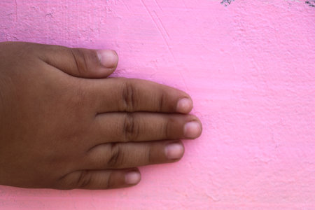 Hand of a child on a pink background. Close-up.の写真素材