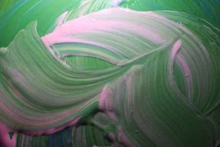colorful abstract background of acrylic paint in green and pink colors.