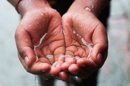 Hands of a child washing their hands with soap and water.