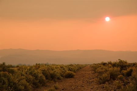 An eerie sunset as the sun appeared below the level of the smoke caused by forest fires in Northern California, which looked like the road to Mordor the ficticious realm in the Lord of the Ringsの写真素材