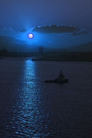 Moonrise over Athens Harbor with tug boat manouvering into positionの写真素材
