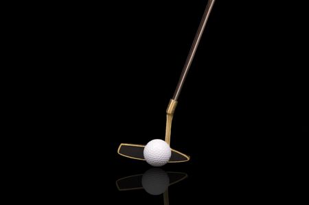 Large Golf putter and ball isolated on black and reflected off of glass surfaceの写真素材