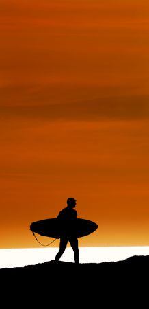 Surfer walking the cliffs to the ocean at Santa Cruz, California for a final sunset rideの写真素材
