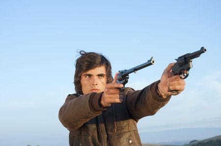 young man in leather jacket on and pistols pointed at target