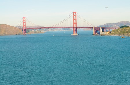 Airship or blimp cruising over San Francisco and the Golden Gate Bridgeの写真素材