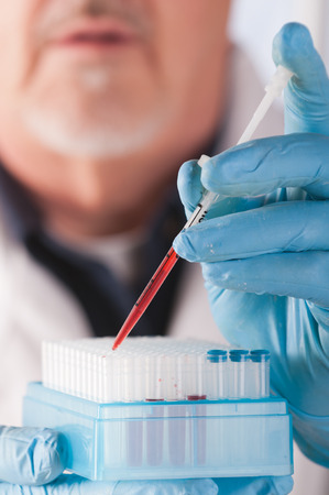 Research scientist with blood samples and culture dish for analysisの写真素材