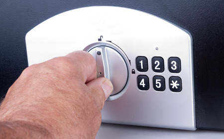 Mans hand opening a safe