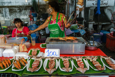 CHIANG MAI, THAILAND - 6/13/2015: A woman cooks seafood at the Sunday walking street market.のeditorial素材