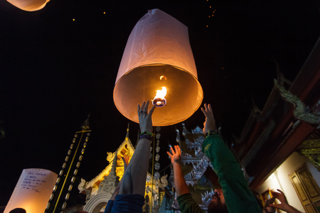 CHIANG MAI, THAILAND - 12/30/2015: A group of tourists release floating lanterns at a Buddhist temple on New Year's Eve in Chiang Mai, Thailand.のeditorial素材