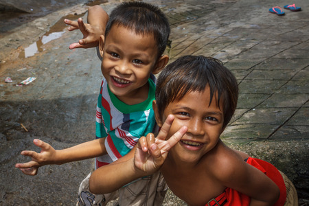 SIHANOUKVILLE, CAMBODIA - 7/20/2015: Two boy play in the streets of their fishing village.のeditorial素材