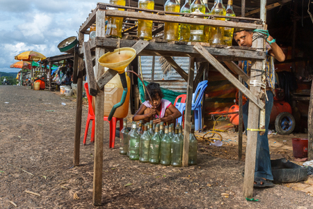 SIHANOUKVILLE, CAMBODIA - 7/19/2015: Two children work the roadside petrol station.のeditorial素材