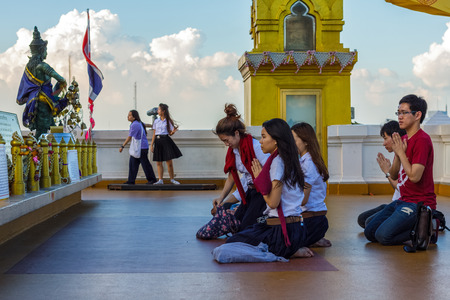 BANGKOK, THAILAND - 11/12/2014: A group of students pray on the roof of Wat Saket, also known as the Golden Mount.のeditorial素材