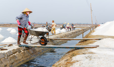 NHA TRANG, VIETNAM - 4/12/2016: A woman works at the Hon Khoi salt fields in Nha Trang, Vietnam.のeditorial素材