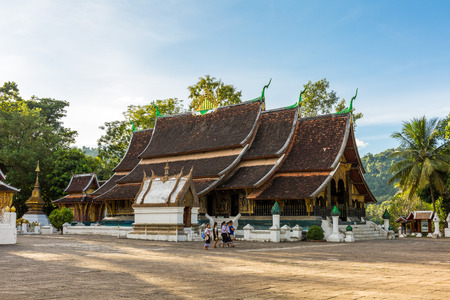 LUANG PRABANG, LAOS - 9/21/2017: School children at Wat Xieng Thong, a Buddhist temple in Luang Prabang, Laosのeditorial素材