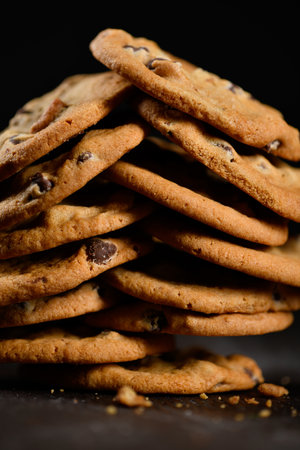 Multiple chocolate chip cookies stacked on black backgroundの写真素材