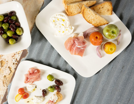 Appetizer plate above view with poached egg, prosciutto, onions, asparagus, bread, tomatoes on an above viewの写真素材