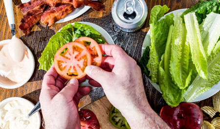 Summertime BLT prep on wooden table with all toppings,の写真素材