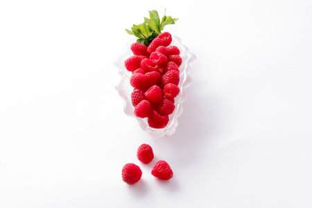 Raspberries in dish on white background with room for messageの写真素材
