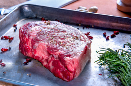 Uncooked steak on tray with pepperの写真素材