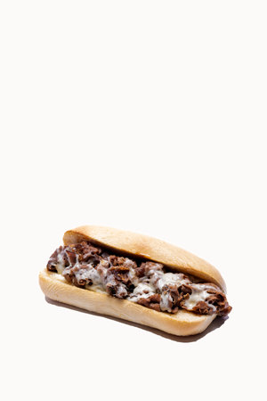Whole philly cheese steak with melting cheese on a white background with message area at top of frameの写真素材