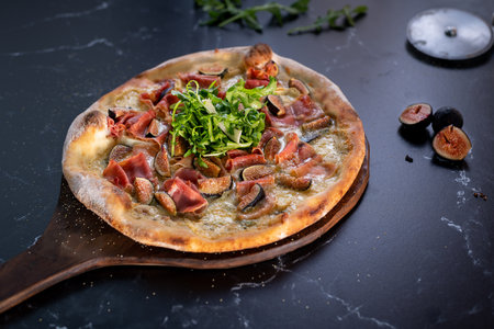 Wood fired fig pizza on pizza peelの写真素材