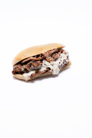 Whole philly cheese steak with melting cheese on a white background with message area at top  or bottom of frameの写真素材