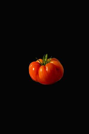 Fresh whole tomato on a black backgroundの写真素材