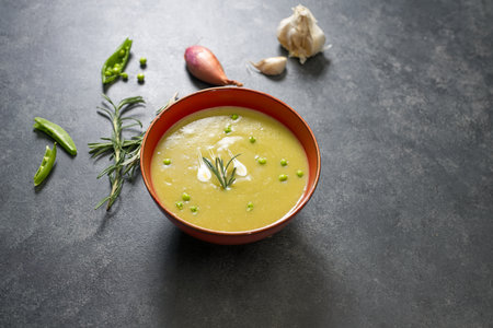 Split pea soup on black table with ingredients aroundの写真素材