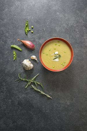 Split pea soup above view on black background with ingredients aroundの写真素材