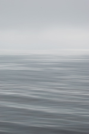 Slow shutter seascape of fog and waves rollingの写真素材