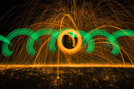 Light painting with steel wool and neon light with effects in orange and green.の写真素材