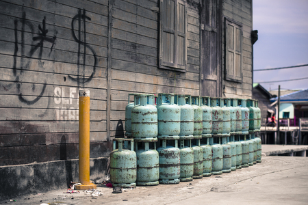 Gas cylinders stacked outside wooden house in fishing village Pulau Ketam, Selangor Malaysia.のeditorial素材