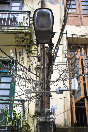 Haphazard disorganized chaotic power cables running along street lightings in Yangon Myanmar Burma South East Asia.のeditorial素材