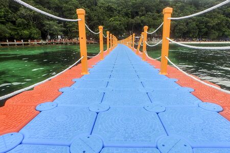 Colorful pontoon floating on seashore connecting boats landing to the beachの写真素材