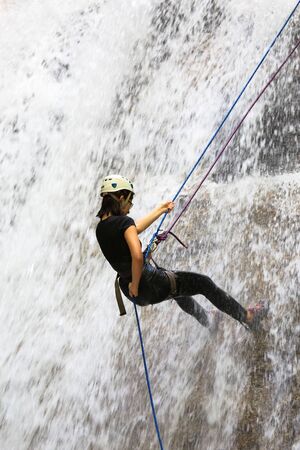 Back view of a person abseiling down a waterfall in Gopeng Perak Malaysiaの写真素材