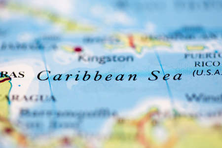 Shallow depth of field focus on geographical map location of Caribbean Sea off coast of Columbia on atlasの写真素材