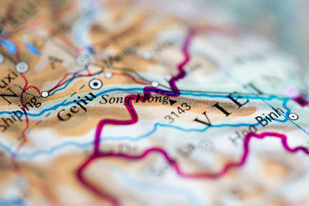 Shallow depth of field focus on geographical map location of Mount Song Hong official name Fansipan in Vietnam Asia continent on atlasの写真素材