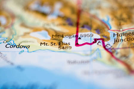 Shallow depth of field focus on geographical map location of Mount Saint Elias in Canada North America continent on atlasのeditorial素材