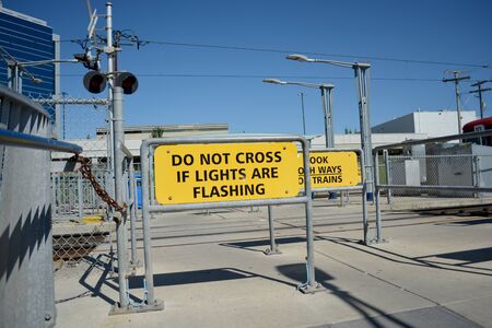 Pedestrian transit train crossing warning signs in city.