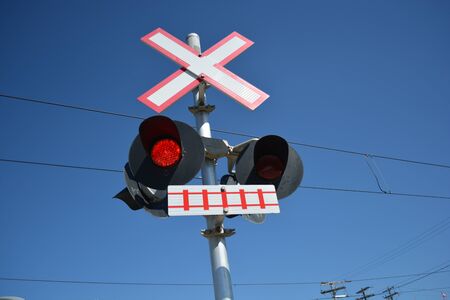 Pedestrian transit train crossing with warning lights.