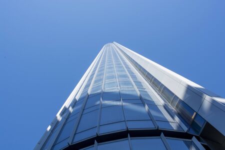 Looking up at curved abstract office tower in downtown core.