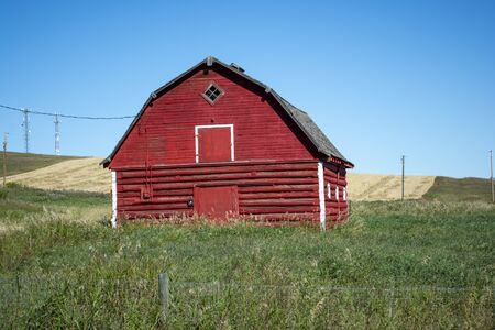 Old Red Barn on Grassy Farmland Prairieの写真素材